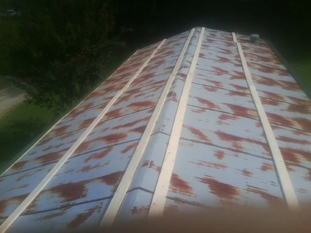 Rusted metal roof panels with new wood purlins before replacement — Storm Damage Roof Repair in Auburndale by Roofing Brothers